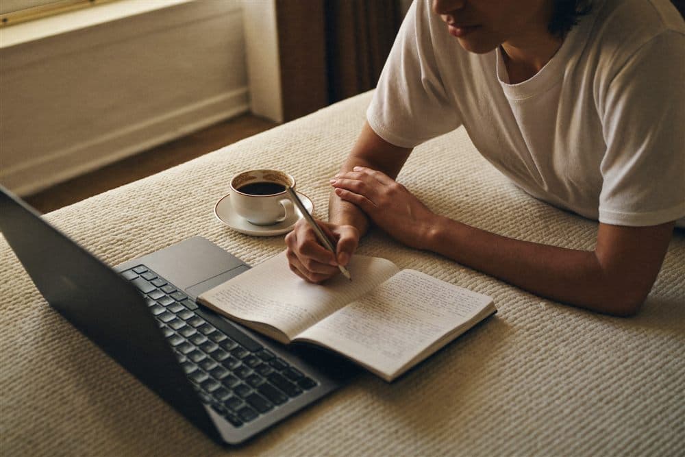 An individual studying at home on a laptop