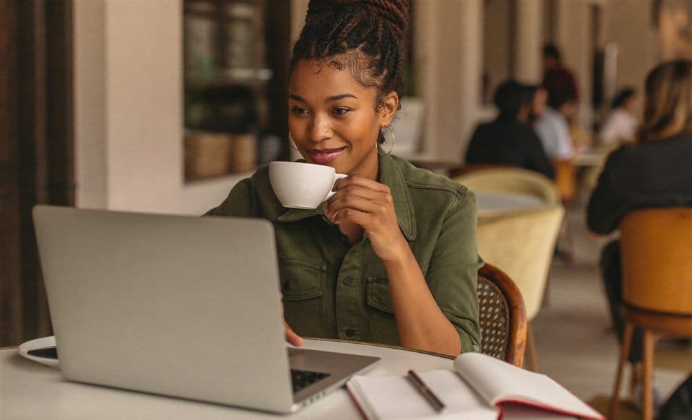 A learner studying on a laptop at a cafe